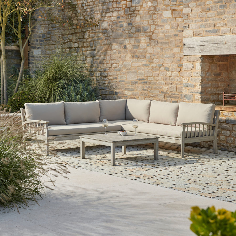 Repton Classic Corner Garden Furniture Set – a wooden outdoor corner sofa with beige cushions, designed for patios and stylish garden seating. This weather-resistant L-shaped sofa set includes a matching wooden coffee table, perfect for outdoor lounging and alfresco gatherings.