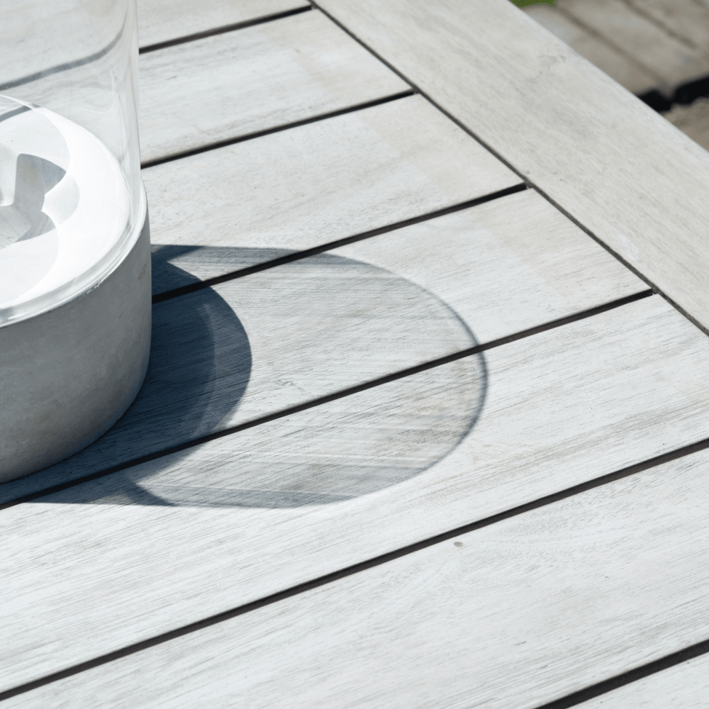 Close-up of the wooden tabletop showing its smooth finish and integrated parasol hole for sun protection on warmer days.