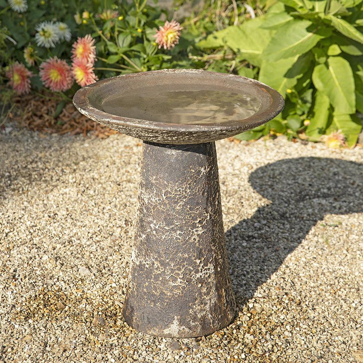 Ancient Salt Glaze Bird Bath in a sunlit garden, featuring a weathered stone-effect finish and a tapered pedestal design for an aged, antique look.