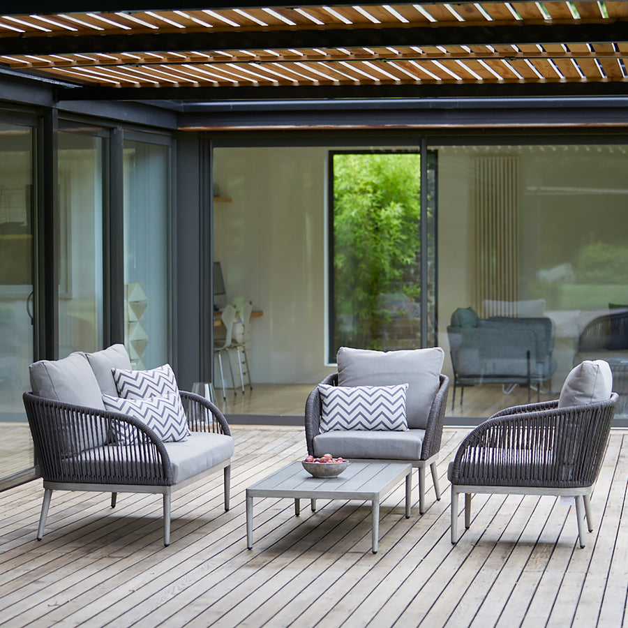 Richmond outdoor sofa set on a wooden deck, featuring a modern rope-woven design, grey cushions, and a sleek aluminium frame for stylish garden lounging.